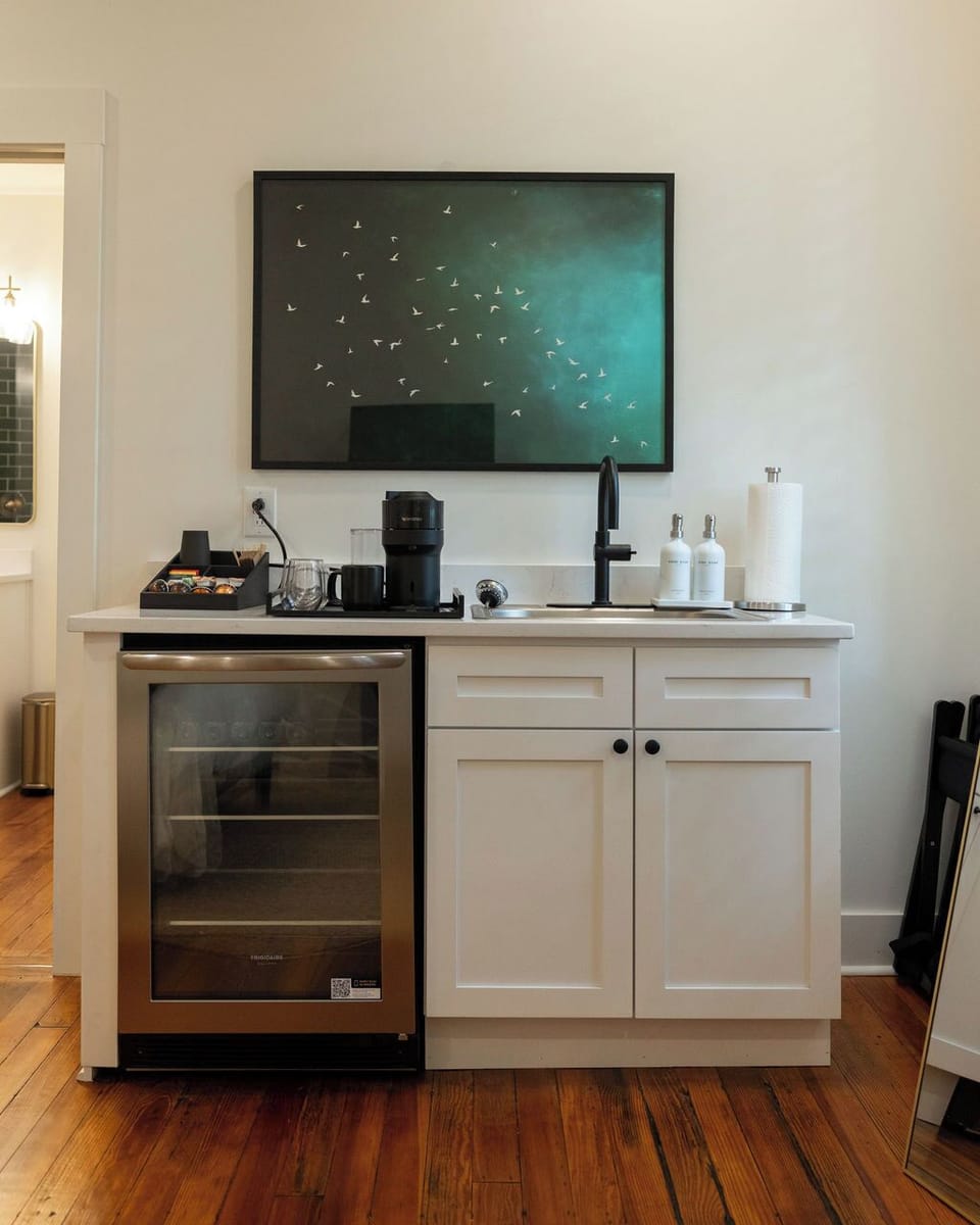 Stylish wet bar with coffee station, beverage fridge, and modern finishes