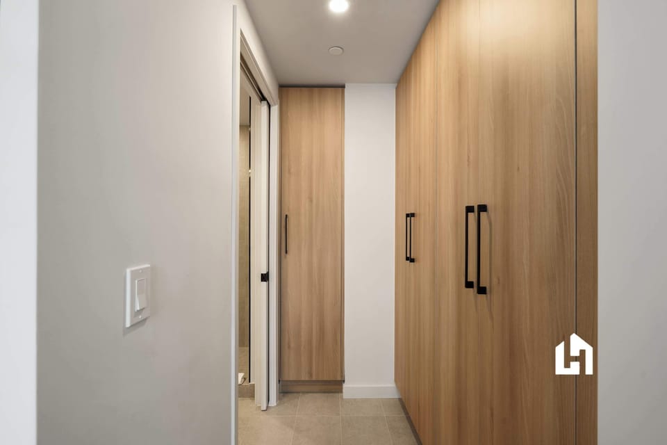 Interior hallway with wood-tone wardrobe and access to both bathrooms

