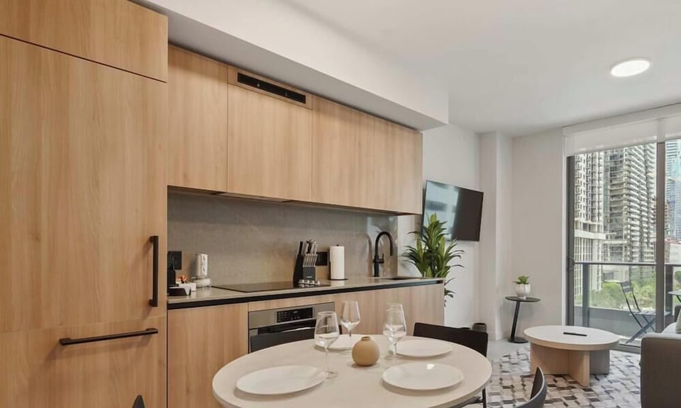 Kitchen and dining area with round table, modern cabinetry and city views
