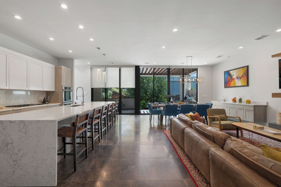Open kitchen, living, and dining flow under soaring East Austin ceilings.