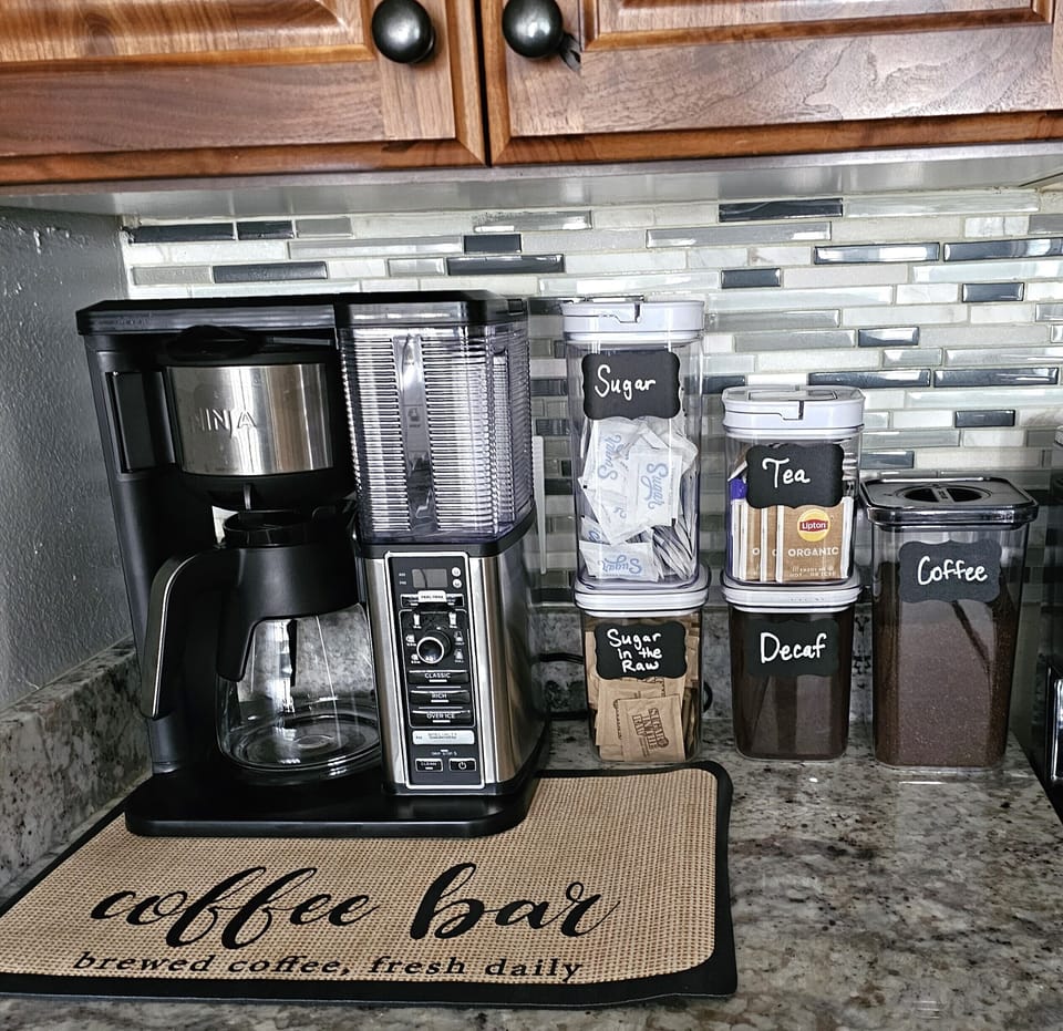 Coffee and Ninja coffee maker, tea and sugar.