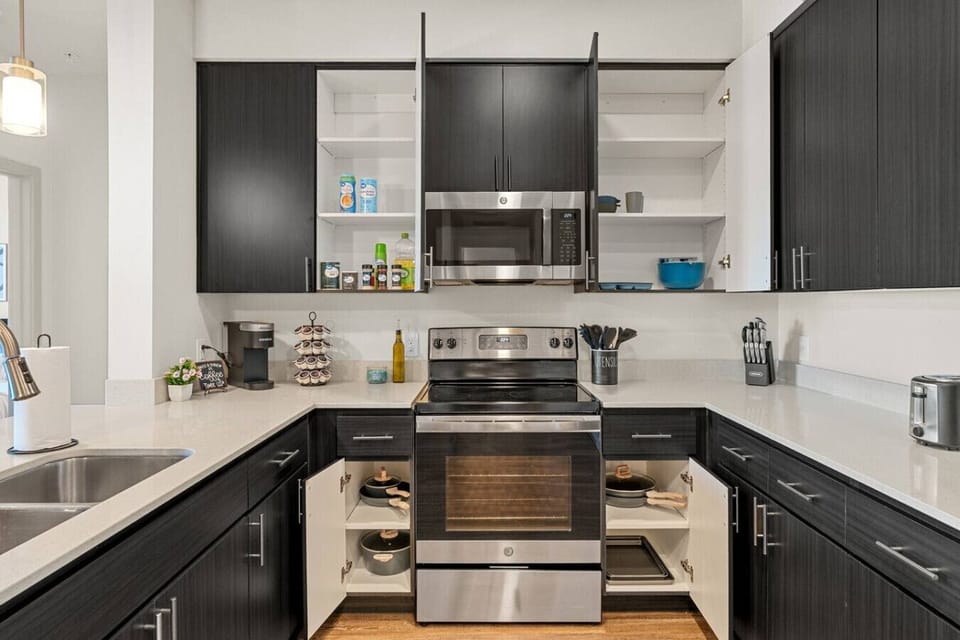 Prepare delicious meals with ease in this fully equipped kitchen, featuring stainless steel appliances, a convenient coffee station, and all the necessary cooking supplies.