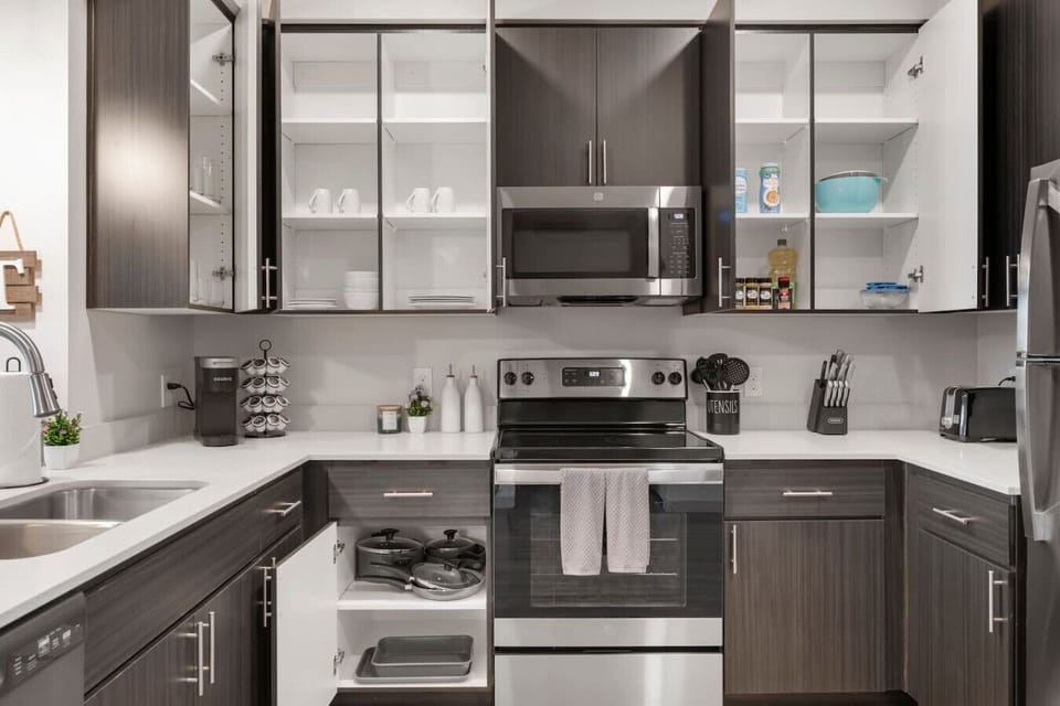 Fully stocked kitchen with stainless steel appliances, a coffee station, and cooking supplies for preparing home-cooked meals.