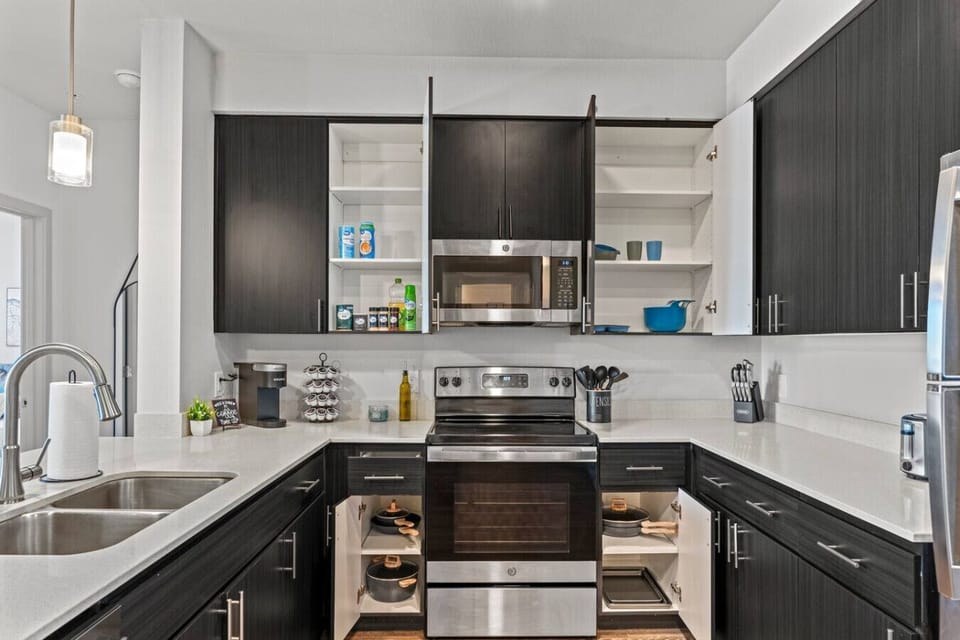 Prepare delicious meals with ease in this fully equipped kitchen, featuring stainless steel appliances, a convenient coffee station, and all the necessary cooking supplies.