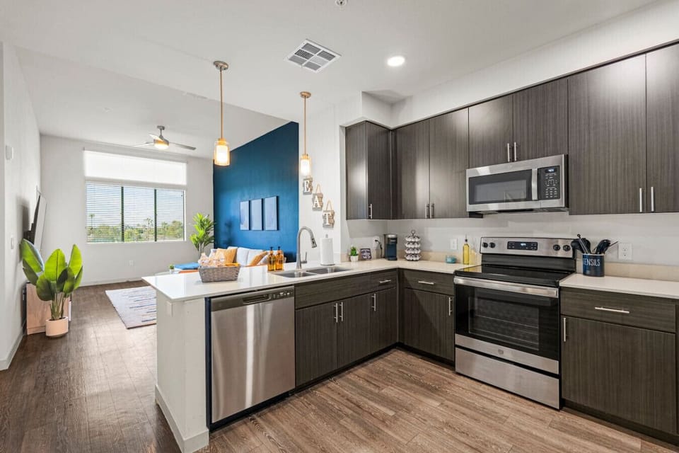 This fully equipped kitchen has everything you need to prepare and enjoy home-cooked meals, including stainless steel appliances, a coffee station, and all the necessary cooking supplies.
