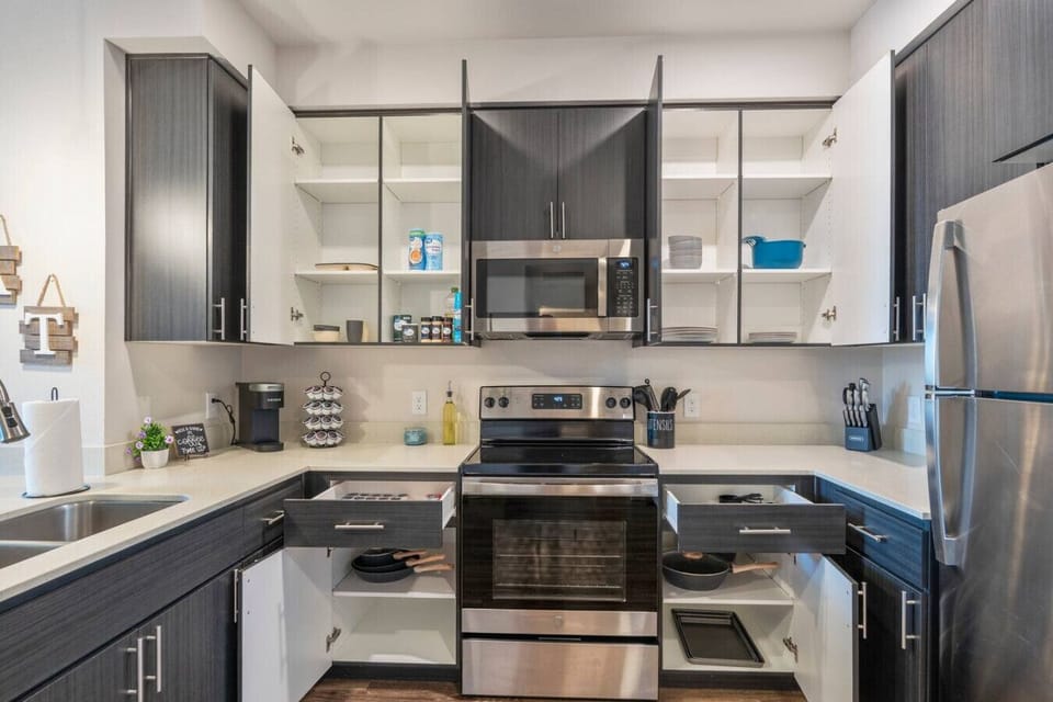 Fully stocked kitchen with stainless steel appliances, a coffee station, and cooking supplies for preparing home-cooked meals.