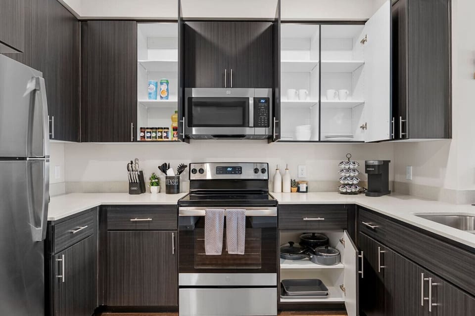 Fully stocked kitchen with stainless steel appliances, a coffee station, and cooking supplies for preparing home-cooked meals.