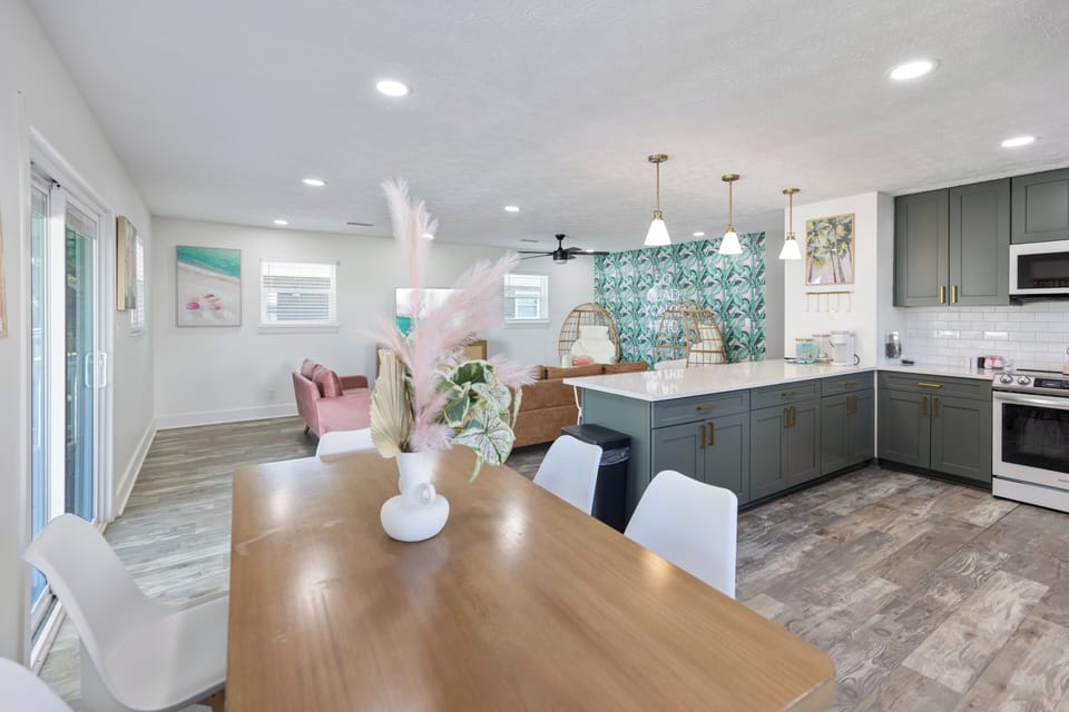 Stylish open-concept living space where the chef's kitchen flows seamlessly into dining and lounge areas. Coastal-chic design meets modern comfort with custom cabinetry and pendant lighting.