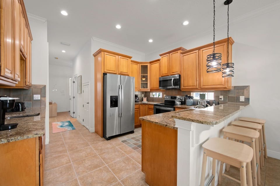 The open-concept kitchen features stainless steel appliances, ample counter space, and everything you need to prepare family meals during your vacation.