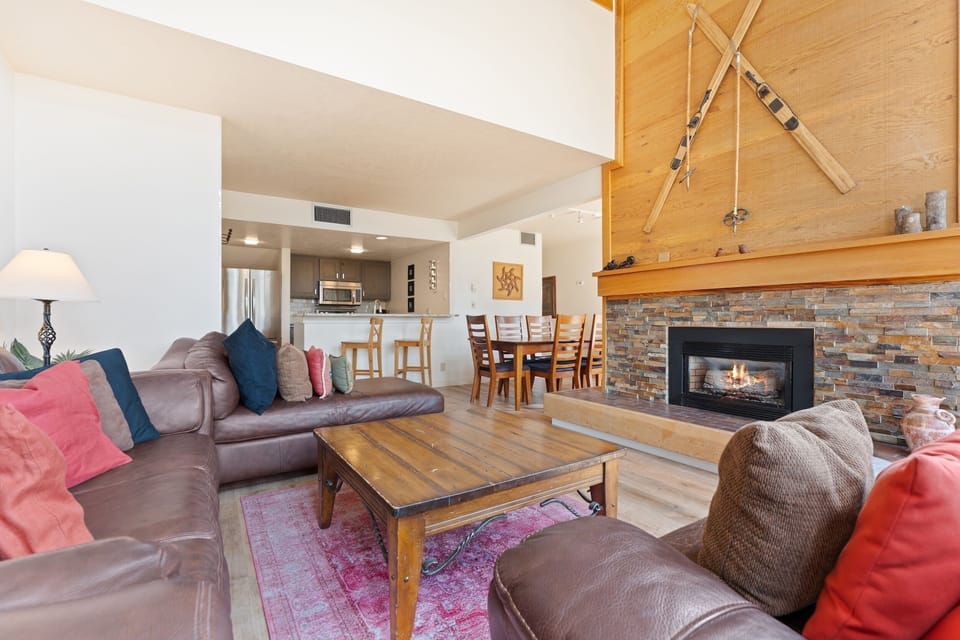 Cozy up by the fireplace in your spacious living area with vaulted ceilings and mountain charm. The open layout connects to the kitchen and dining space, perfect for gathering after a day on the slopes.