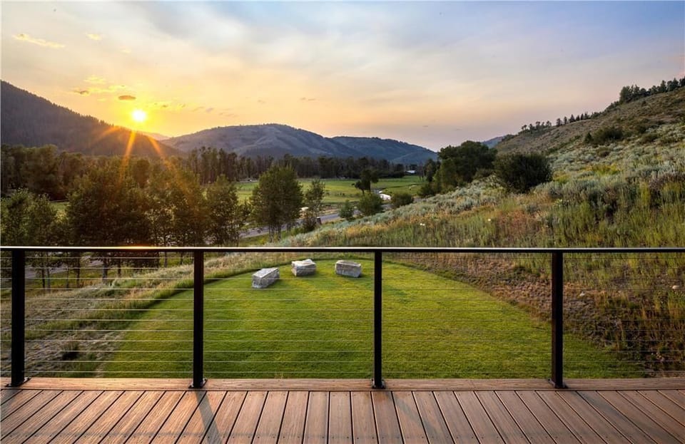 Wooden deck with rolling hills and mountain views at dusk