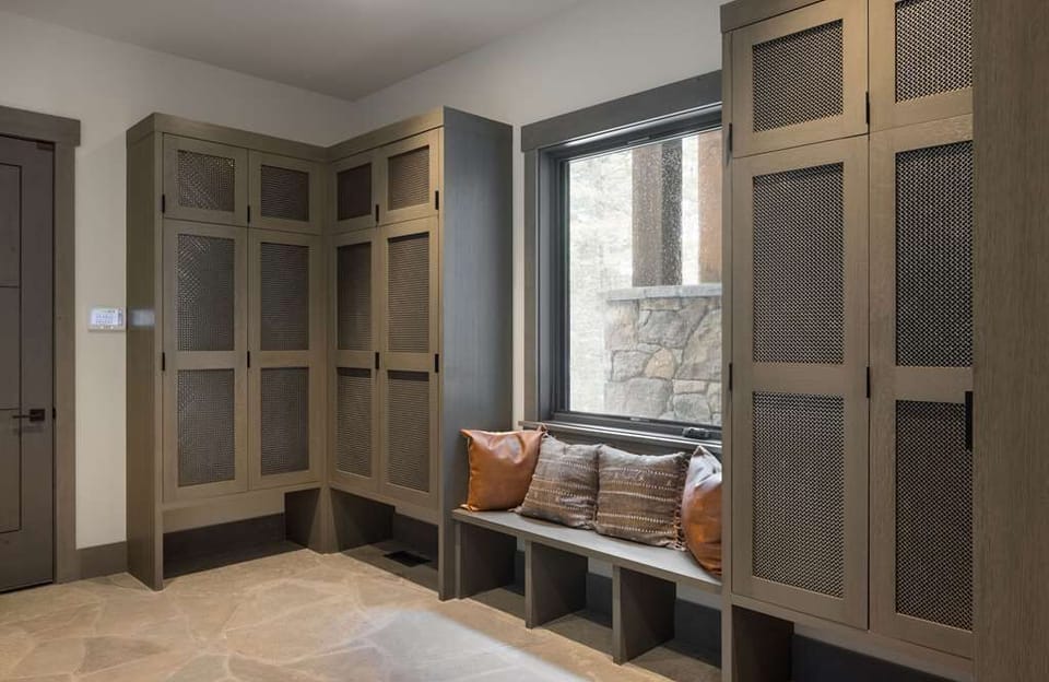 Built-in cubbies line the mudroom, with a window seat tucked in for boots and gear.