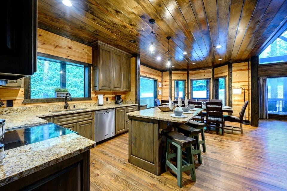 Open kitchen and dining area with island seating and warm cabin finishes.