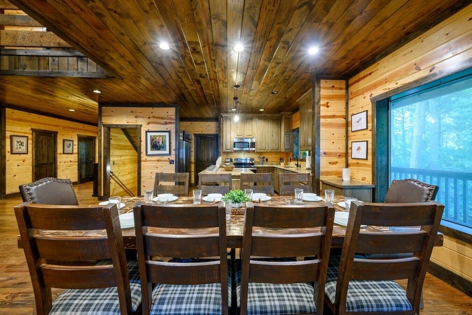 Large dining table set beside the kitchen and deck doors.