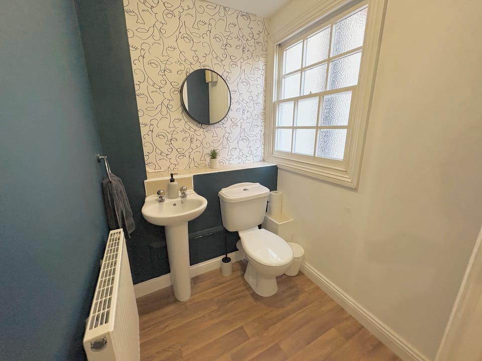 Bright modern bathroom with natural light and stylish feature wallpaper