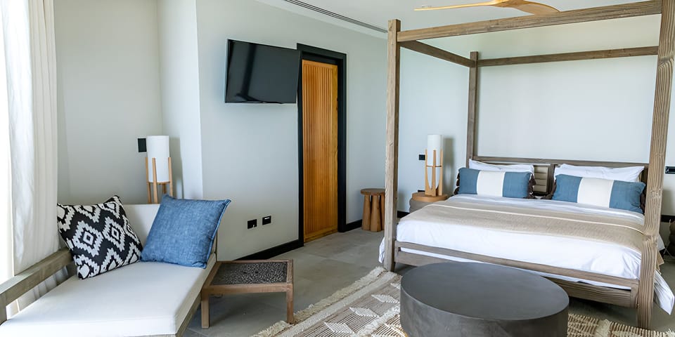 Wake slowly in a calm bedroom with cozy lounge seating.
