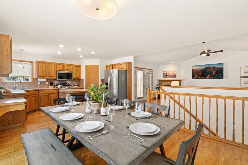 Gather around the welcoming dining table, where warm wood tones and natural light create the perfect backdrop.