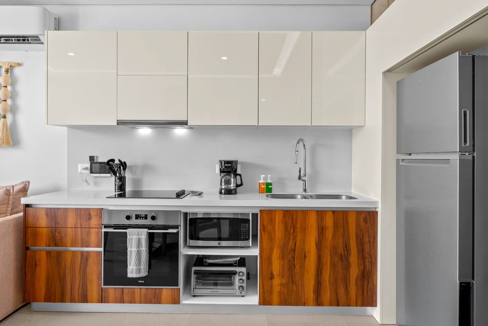 Cook your favorite meals with ease! This contemporary kitchenette maximizes space with sleek white upper cabinetry.