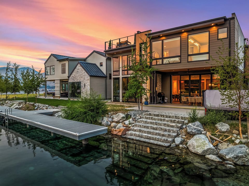 Modern waterfront retreat with private dock, patio, and glowing sunset views