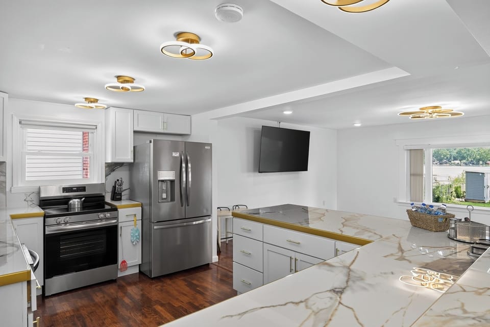 Bright modern kitchen with marble-look counters and stainless appliances
