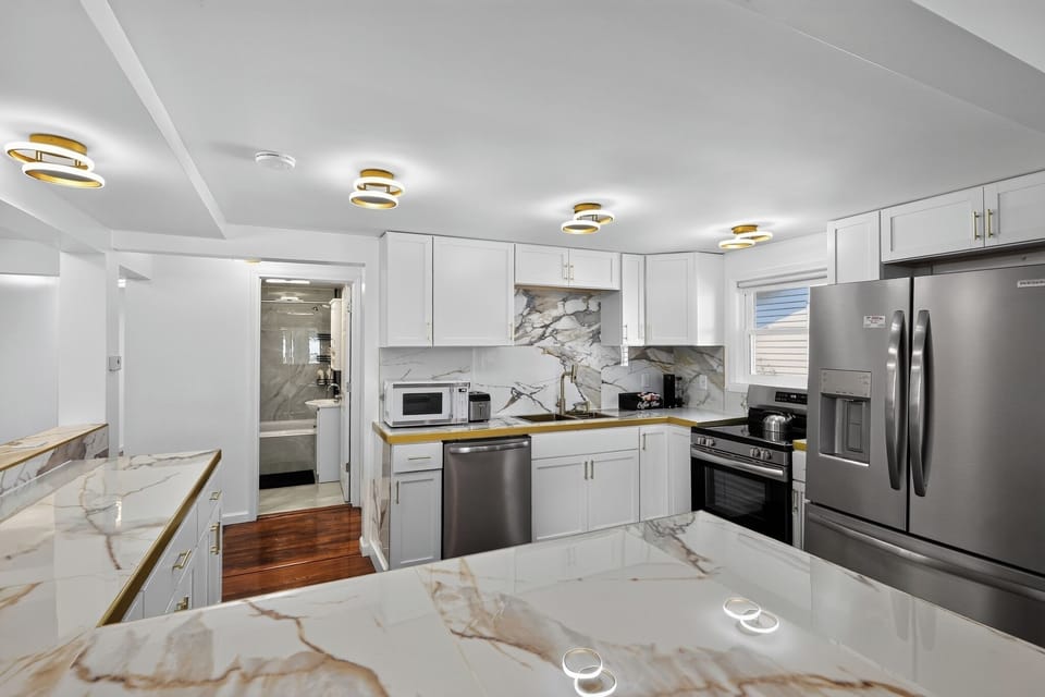 Bright modern kitchen with marble-look counters and stainless appliances