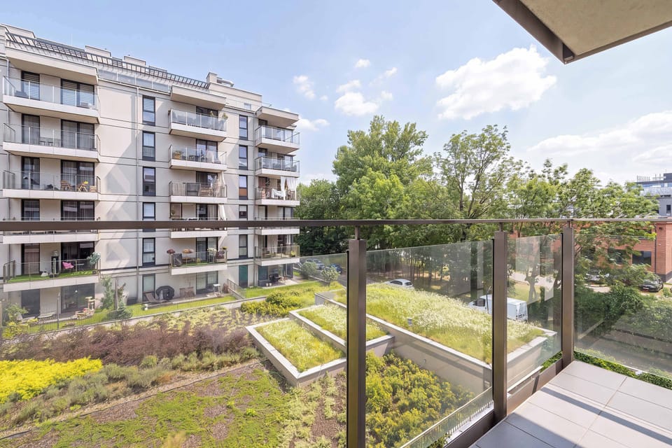 The balcony offers pleasant views of the surrounding buildings and green courtyard. It's a peaceful place to enjoy fresh air throughout the day.