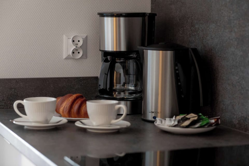 A stylish close-up of a coffee machine and accessories prepared in the apartment. The small details create a cozy and welcoming feeling for guests.