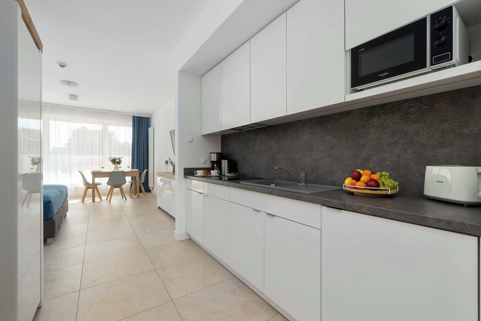 A close view of the stylish kitchen area featuring elegant white cabinetry and a spacious countertop. The minimalist design provides a clean and comfortable cooking environment.