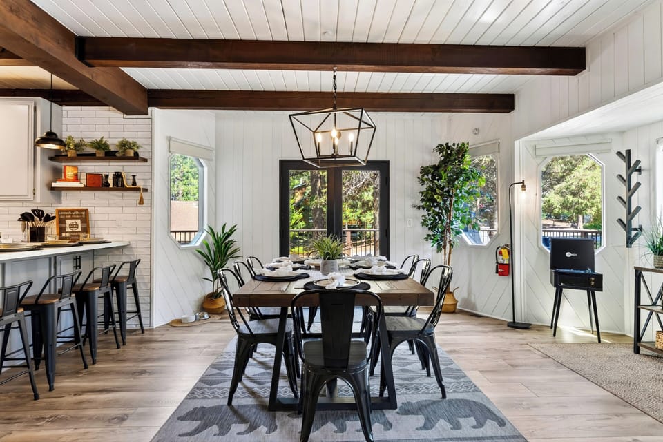 Enjoy easy flow between the dining area, kitchen, and fireside living room beneath exposed wood beams.