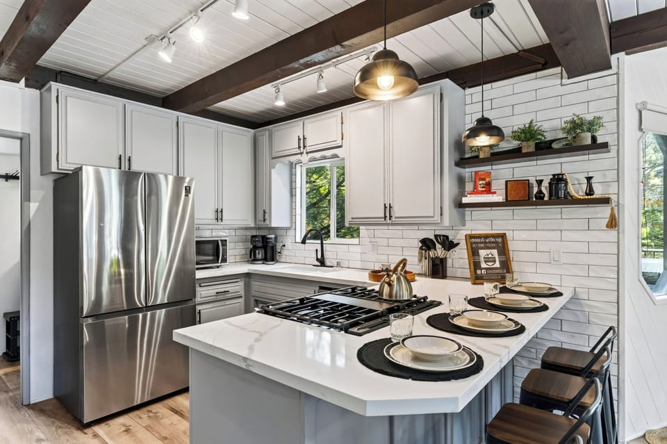 Cook and gather in the bright kitchen, featuring modern appliances and island seating for four.