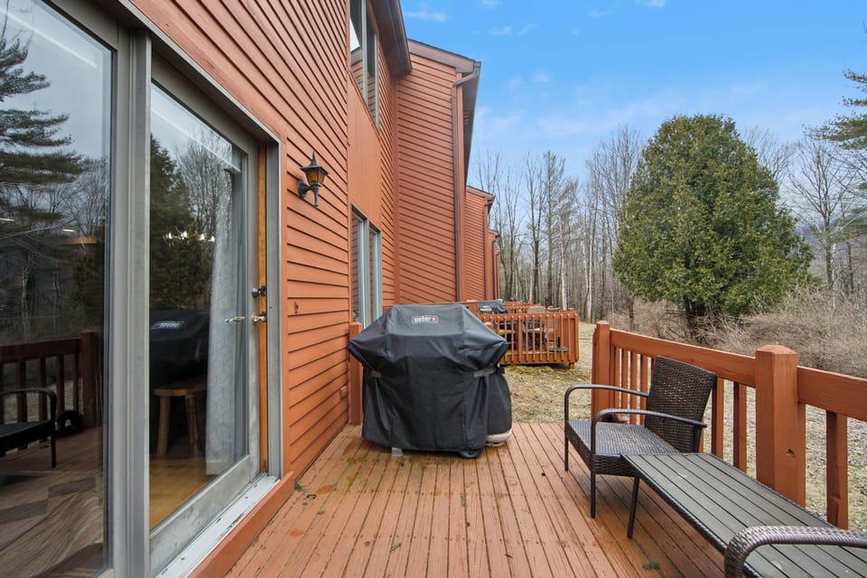 Step outside to a private deck with a gas grill, seating, and quiet woodland surroundings. (Sagamore)