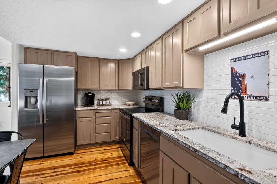 Fully equipped kitchen with granite countertops, wooden cabinetry, and stainless steel appliances.