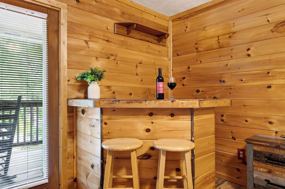 Cozy indoor wooden bar area complete with barstools and a wine glass setup.