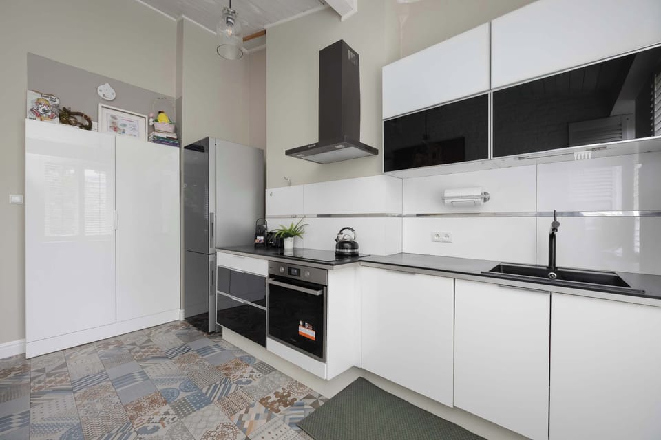 Sleek, fully equipped kitchenette with modern appliances, ample workspace, and plenty of storage.