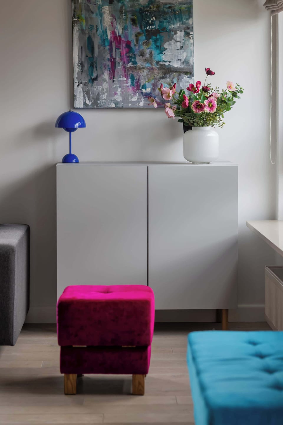 A stylish decorative corner with colorful seating and artwork. Thoughtful details add character to the apartment.