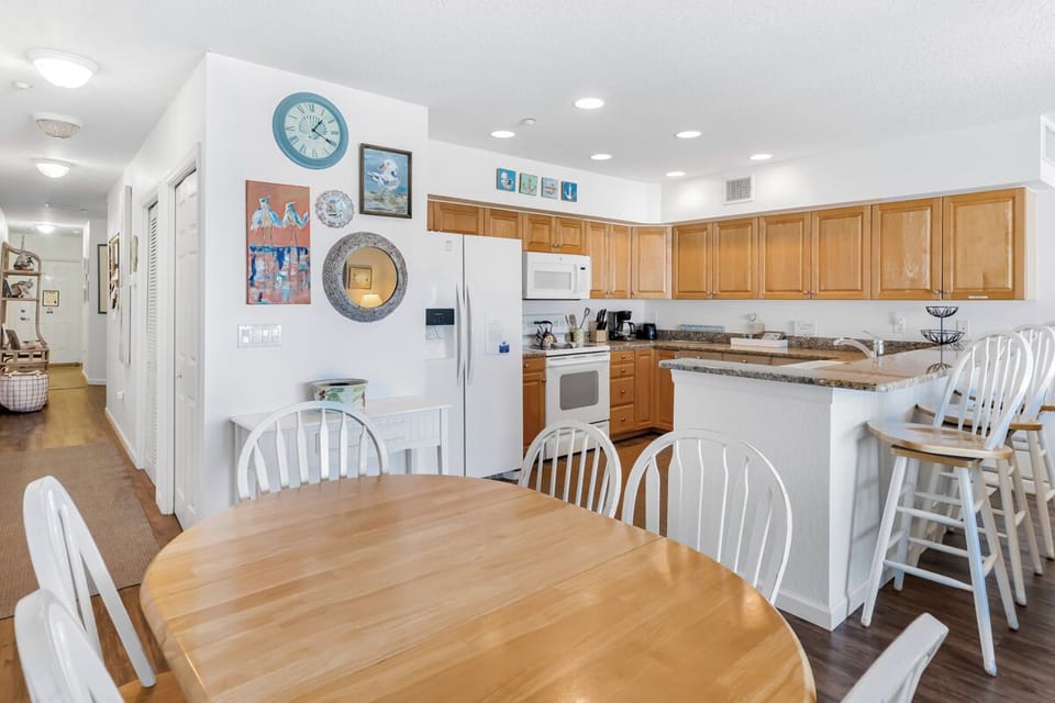 Your spacious kitchen and dining area combines modern appliances with coastal charm, perfect for preparing meals and gathering together.