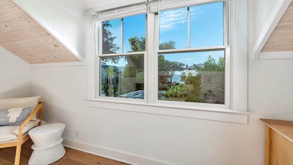 Wake up to glimpses of sparkling water framed by lush greenery through your bedroom window, where sunlight and fresh air greet you each morning.