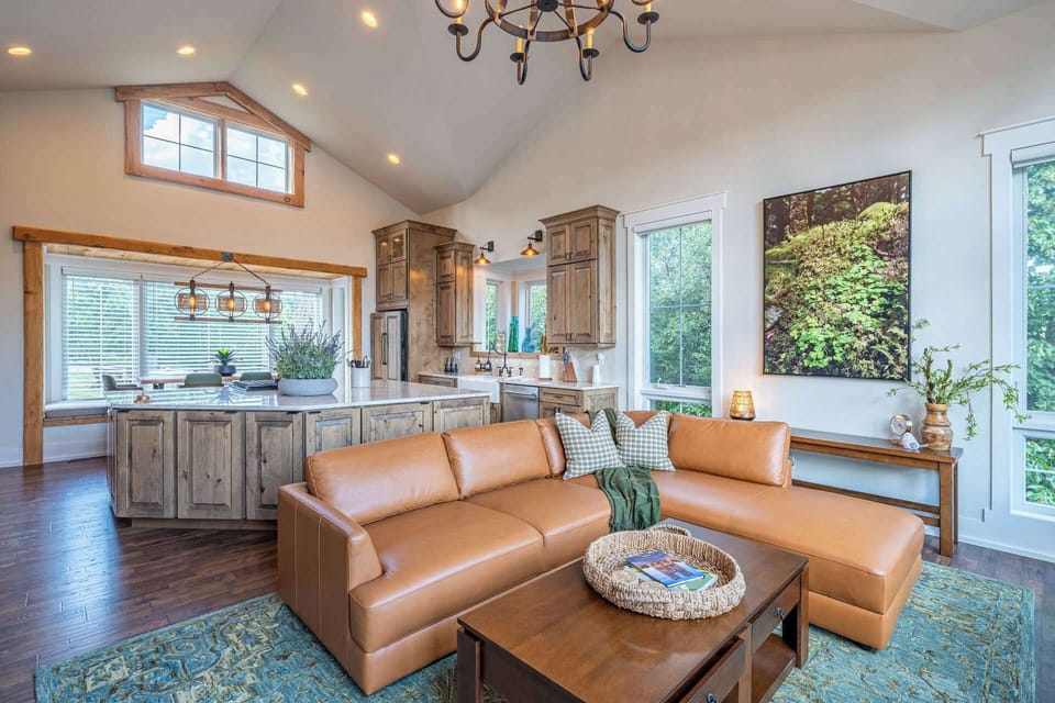 Open-concept living area with kitchen access, forest views and generous gathering space