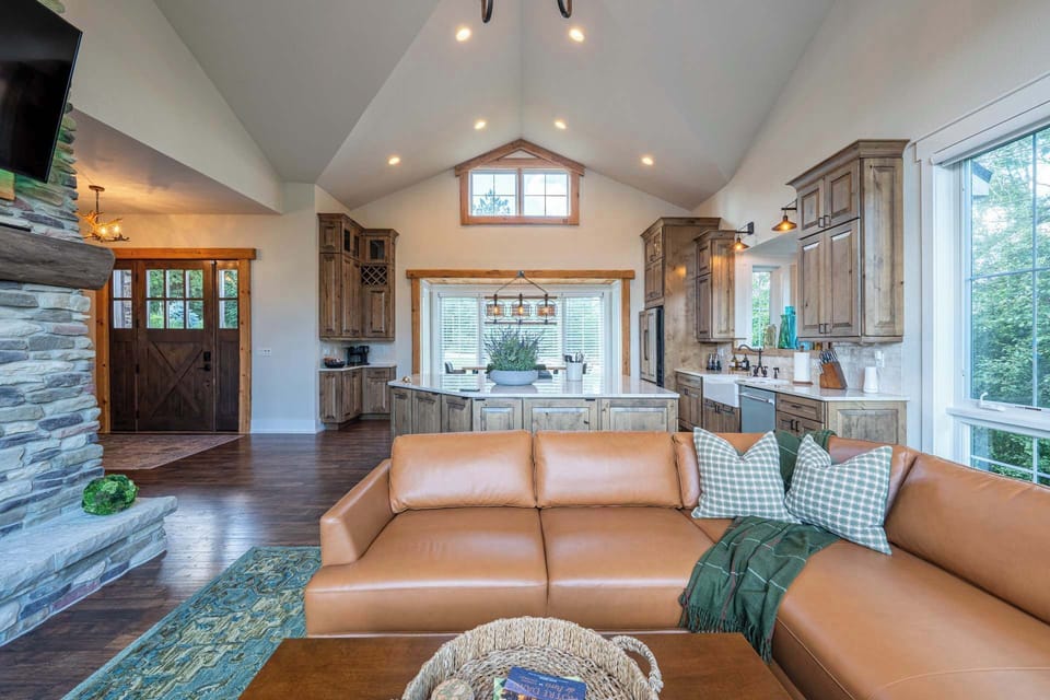 Open living room flowing directly into the kitchen beneath vaulted ceilings