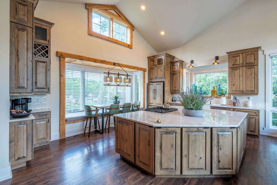 Spacious kitchen with a center island, rustic cabinetry and vaulted ceilings