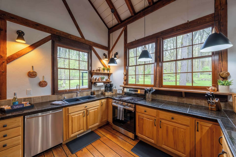 Wide kitchen workspace with granite counters, stainless appliances and abundant natural light