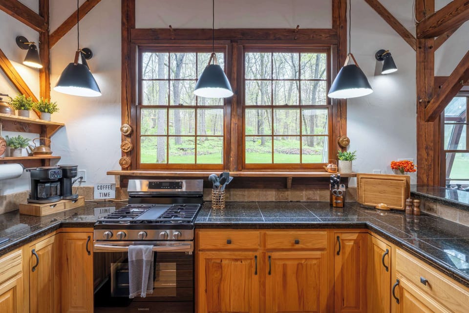 Well-equipped kitchen prep area with a gas range, generous counters and windows over the workspace