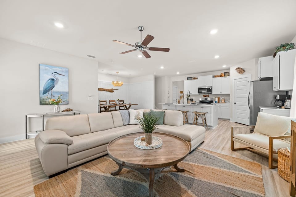 Sink into the plush sectional and unwind in your open-concept retreat. Coastal-inspired décor, ceiling fan breezes, and a fully equipped kitchen create a breezy, welcoming atmosphere for your coastal escape.