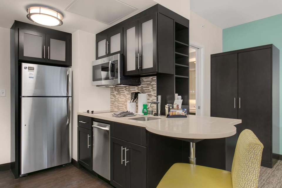 Full kitchen with stainless steel appliances and counter seating.