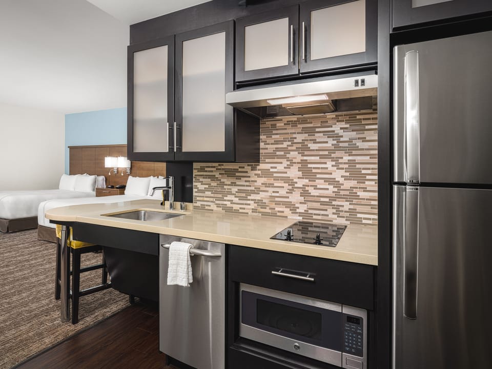Full kitchen with modern appliances and seating area.