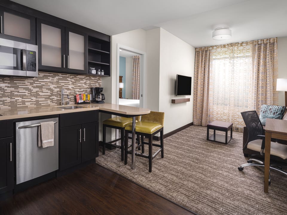 Open kitchen and living area with dining table and TV.