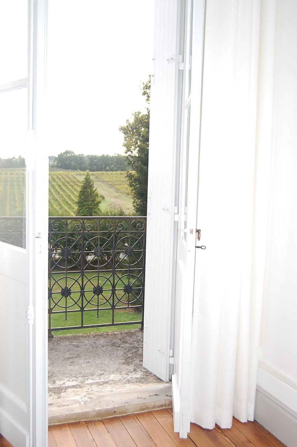 A window looking out over the estate's organic vineyards, a view that defines every stay at this Côtes de Bourg retreat.