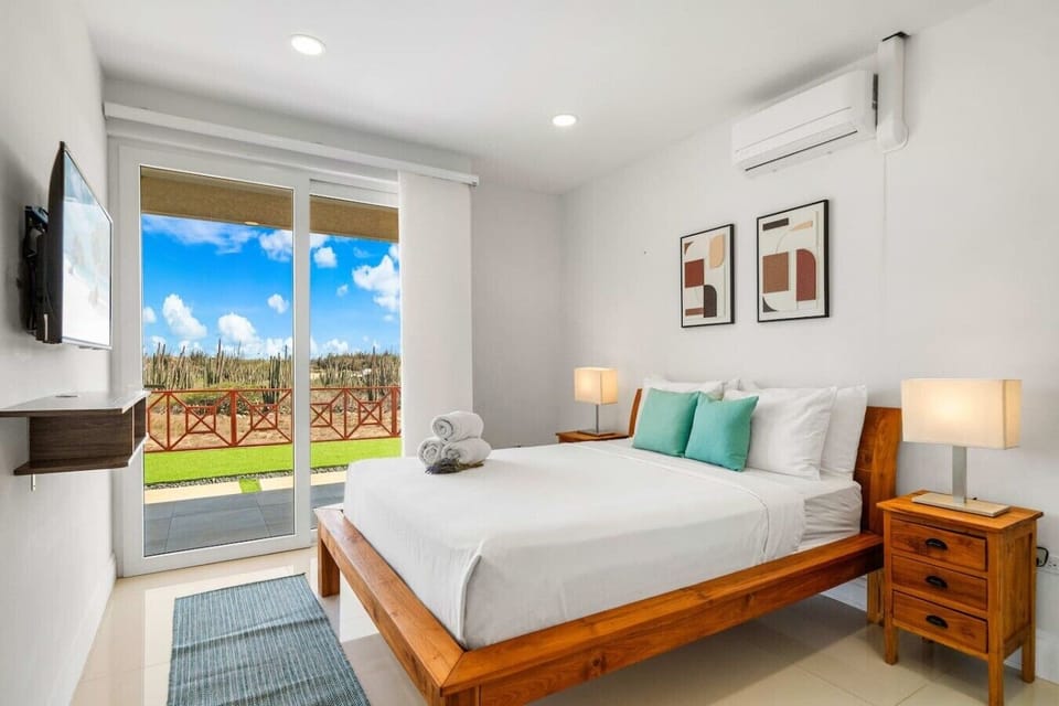 Wake refreshed in a bright, comfortable bedroom where modern decor and scenic views create a peaceful private retreat after full days exploring beautiful Aruba.