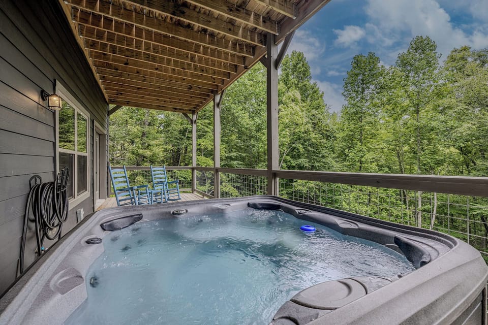 Blue Smoke Soak offers a private hot tub experience surrounded by the wooded mountain setting.