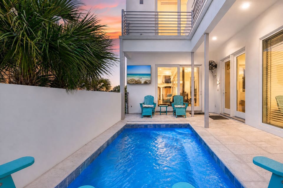 White Sands' private pool glows at bright sunset beside the main living level—an inviting private retreat after days on Destin's sugar-white sand.